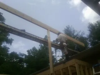 Carpenter setting a ridge beam over a new addition frame — Ice Dam Removal by Roofing Brothers in Bergton