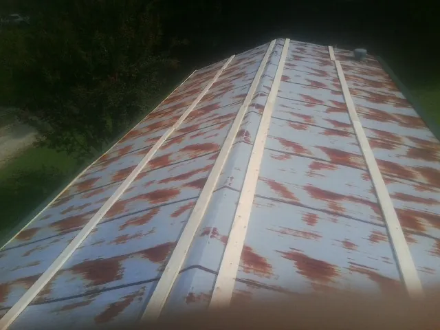 Rusted metal roof panels with new wood purlins before replacement — Storm Damage Roof Repair in Bergton by Roofing Brothers