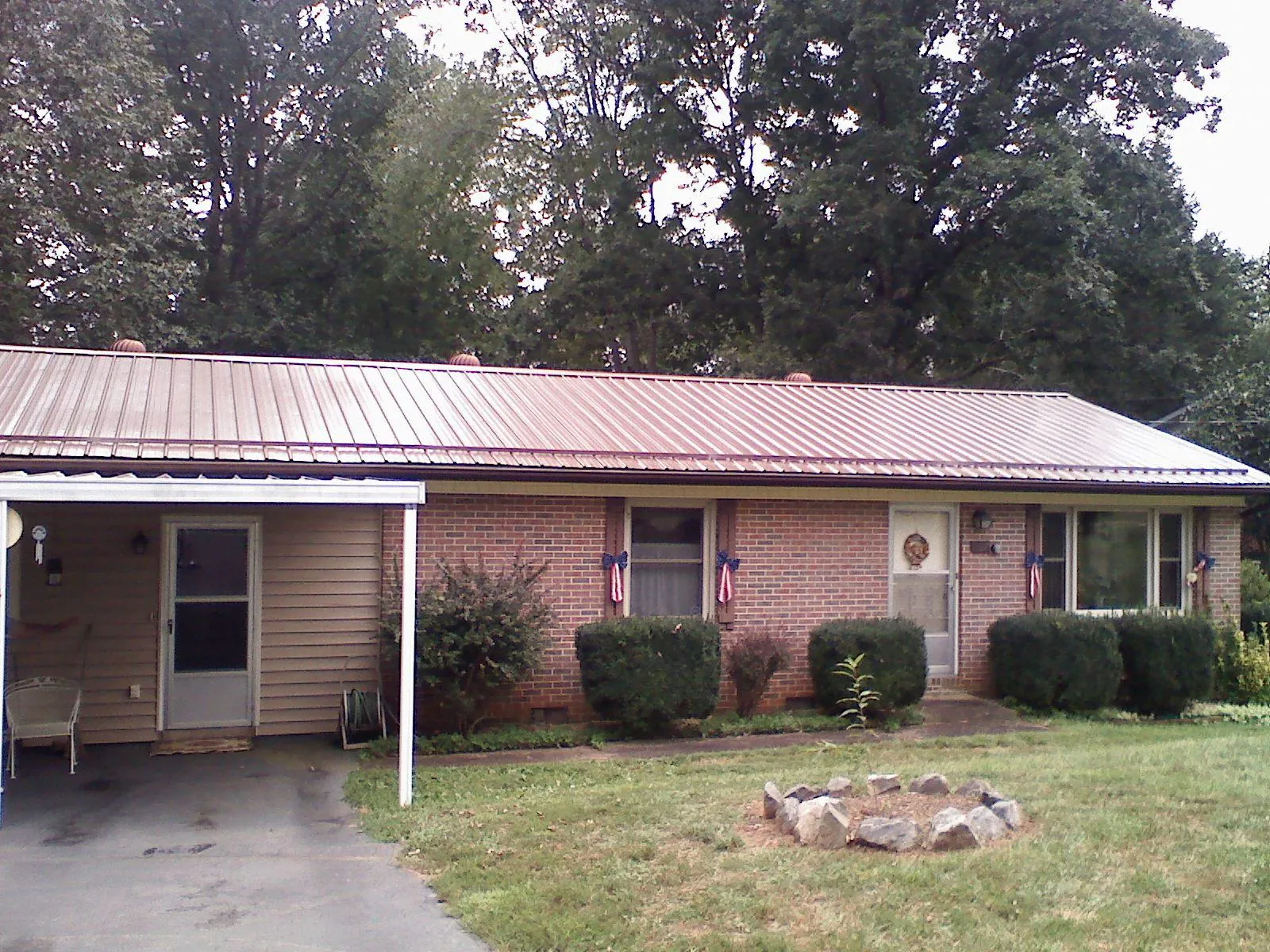 Bronze metal roof and carport on a brick ranch home — Roof Repair work by our crew in Bergton